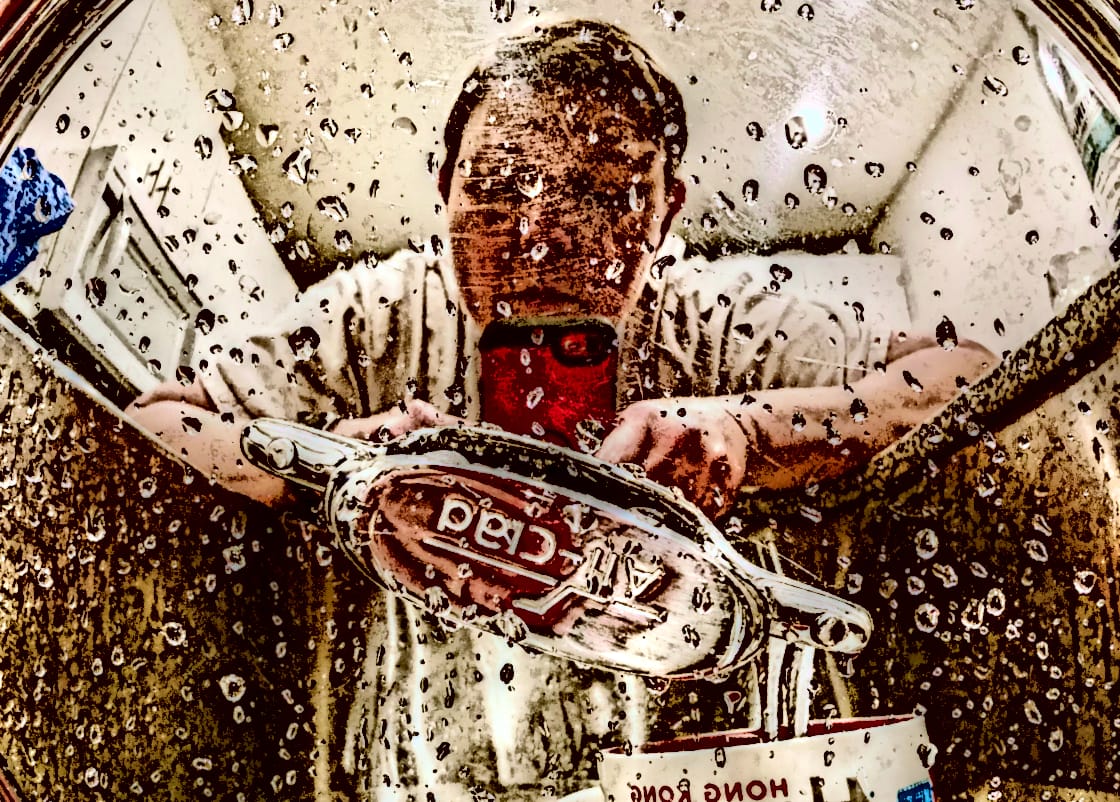 A heavily-edited reflection of me and my iPhone from the perspective of the lid of an All-Clad skillet in my kitchen sink. A Hong Kong mug from Starbucks flips its own image in shame.